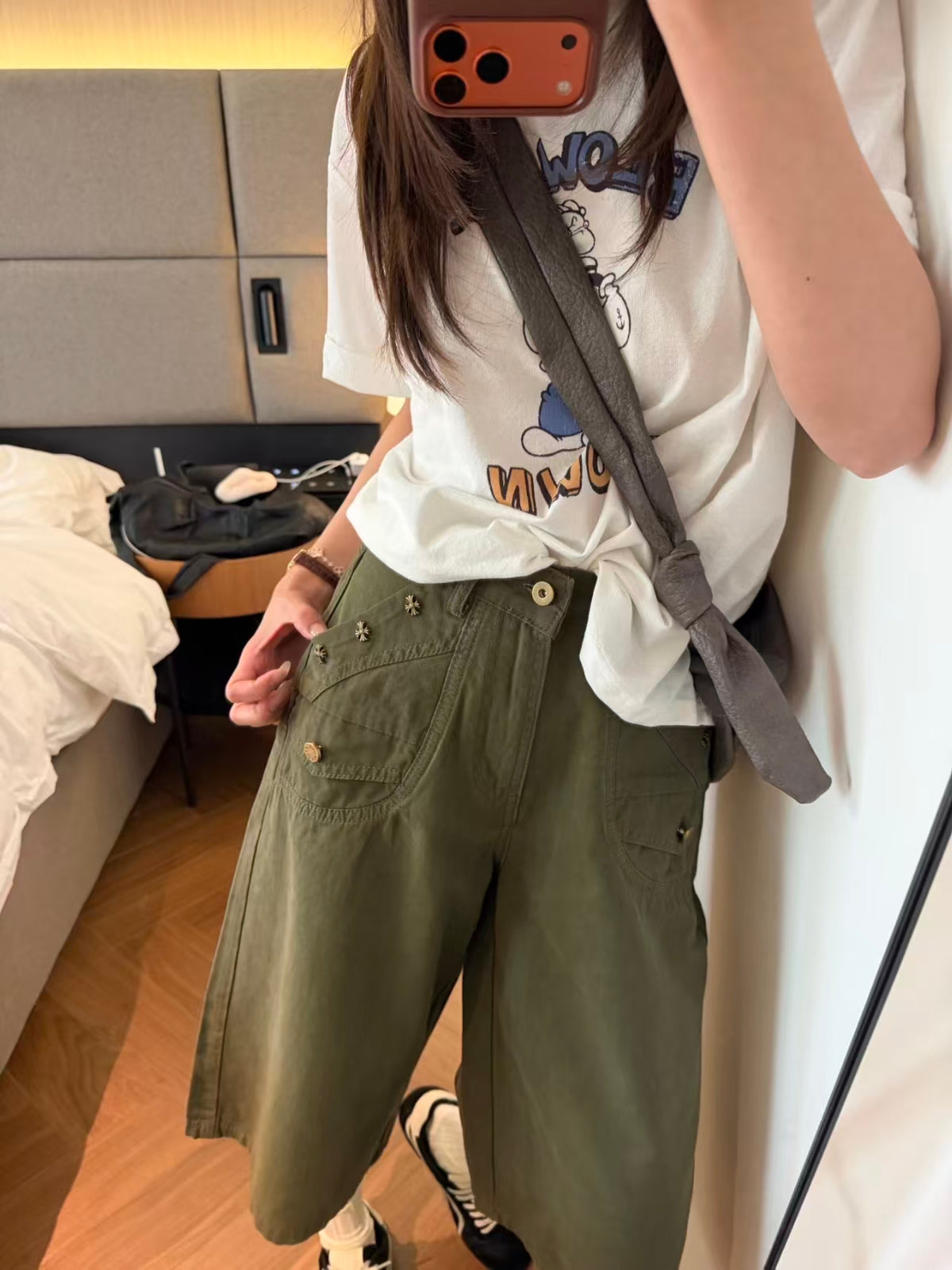 Close-up of antique cross stud pocket detail on green pants